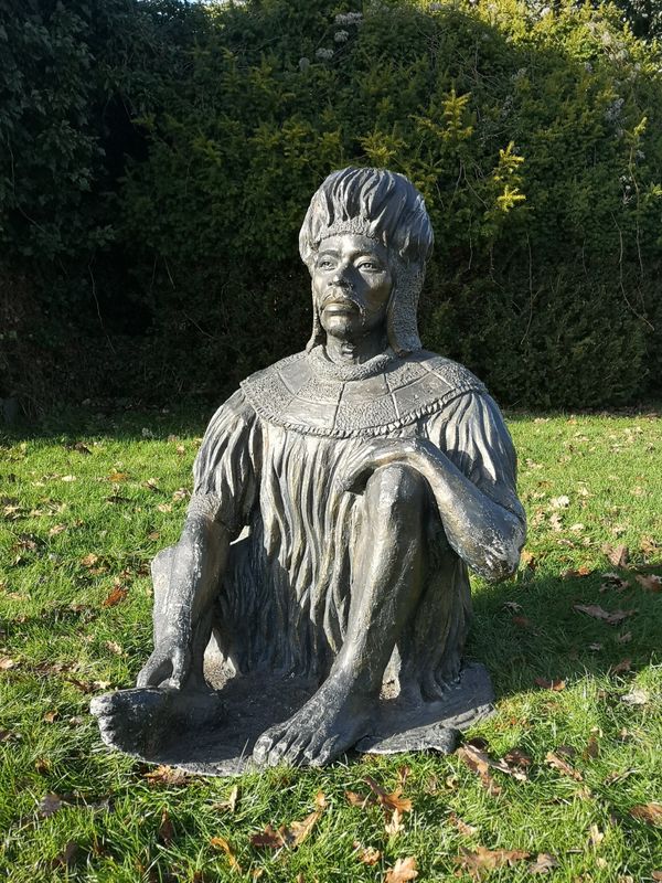 A patinated fibreglass figure of a seated Zulu warrior