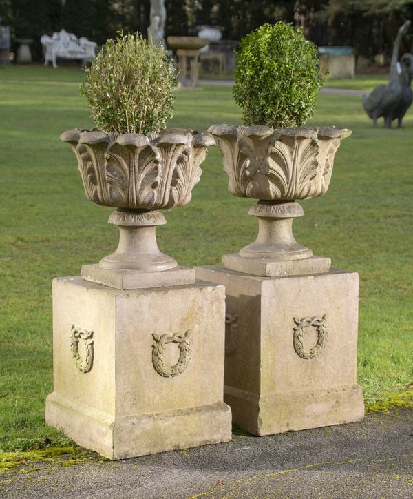 A pair of stoneware urns on pedestals
