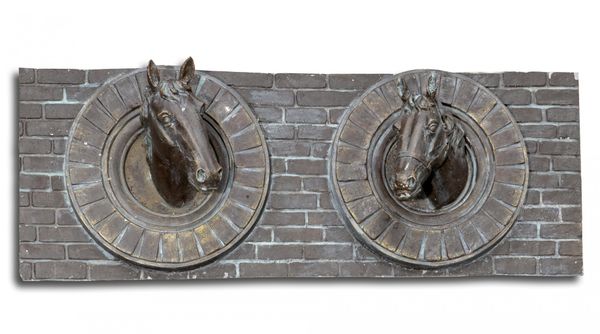 A bronzed fibreglass wall plaque of two horse's heads