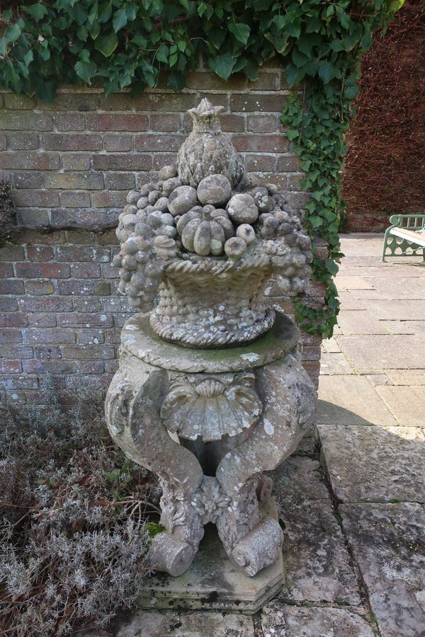 A  composition stone fruit basket on pedestal