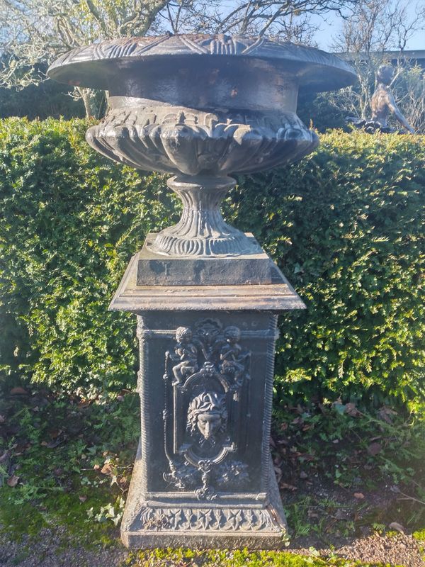 A  large cast iron urn on pedestal