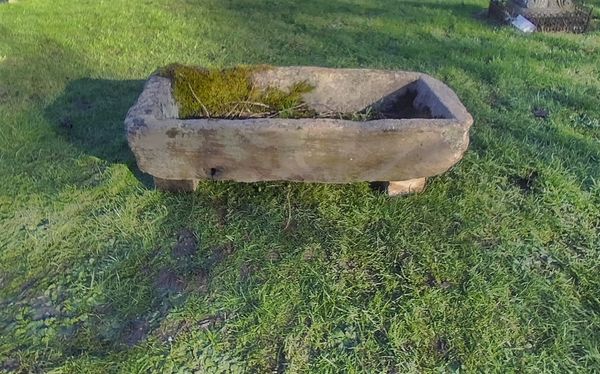 A small carved rectangular limestone trough
