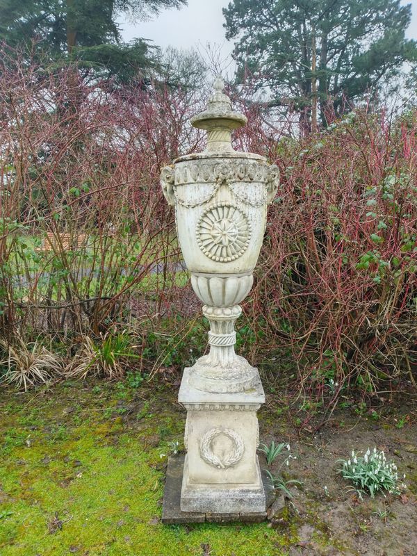 A composition stone finial on pedestal