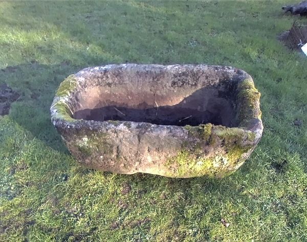 A rounded rectangular carved stone trough
