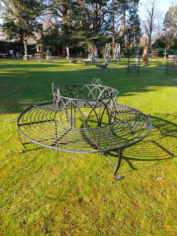 A  wrought iron tree seat in two halves