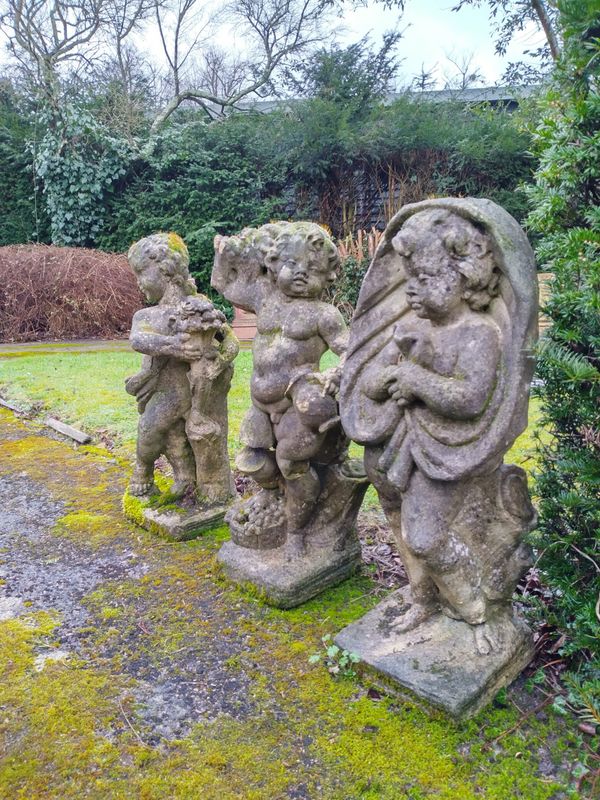 † A set of three composition stone putti