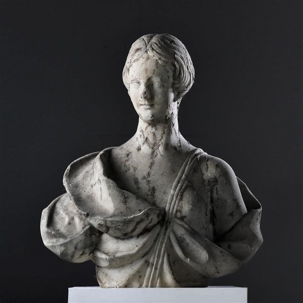 A carved white marble bust of a woman