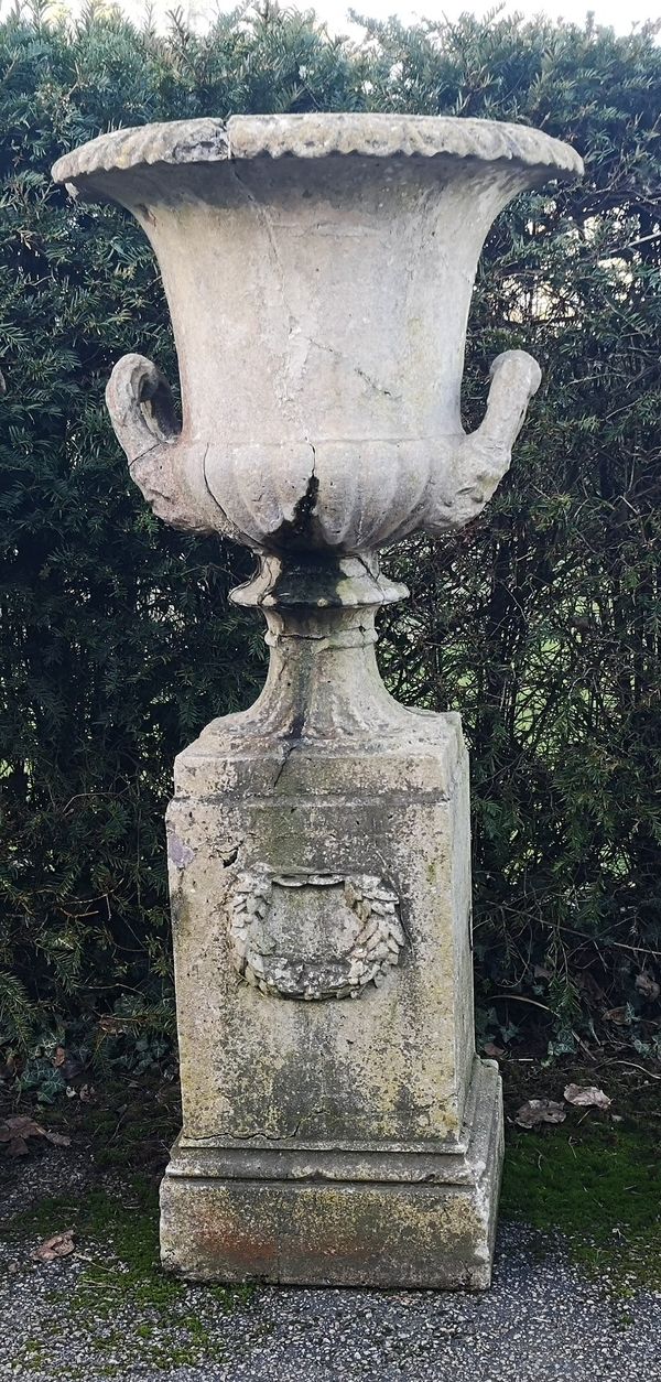 A compostion stone urn on pedestal