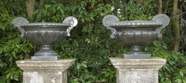 A pair of unusual carved green granite urns