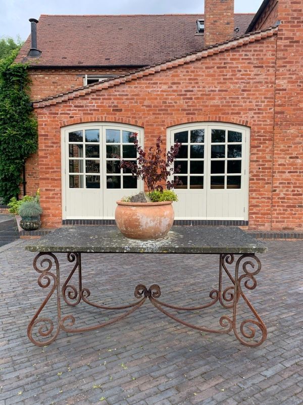 A wrought iron and sandstone table