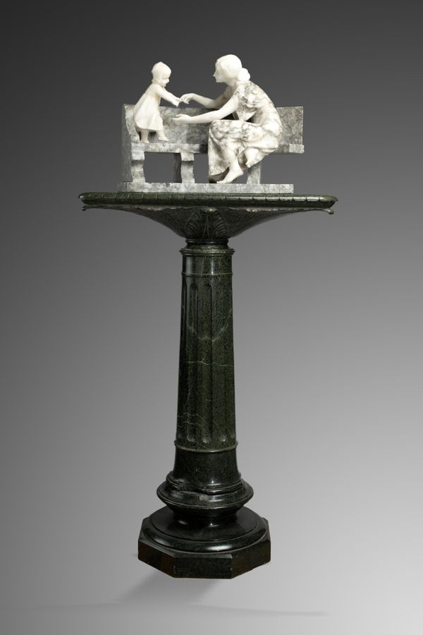 A carved alabaster group of mother and child on garden seat
