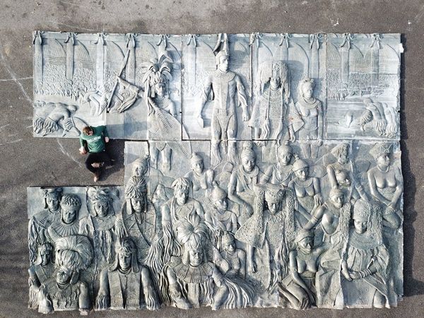 A massive and impressive patinated fibreglass plaque decorated in relief with tribal figures