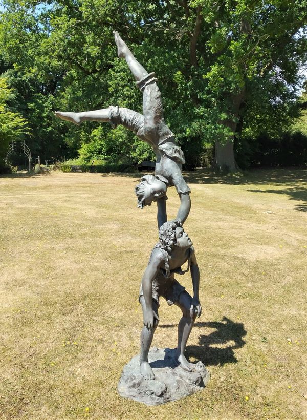 A bronze group of two boys playing acrobats