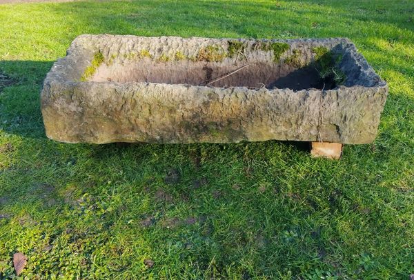 A roughly hewn rectangular carved stone trough