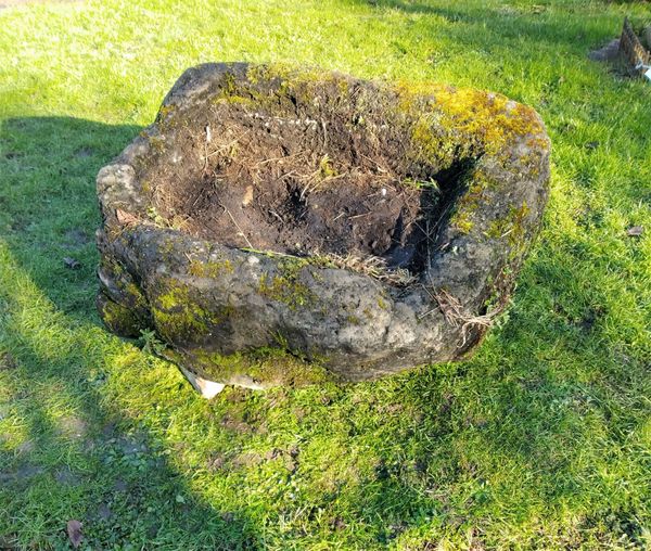 A roughly hewn irregular shaped  carved stone trough