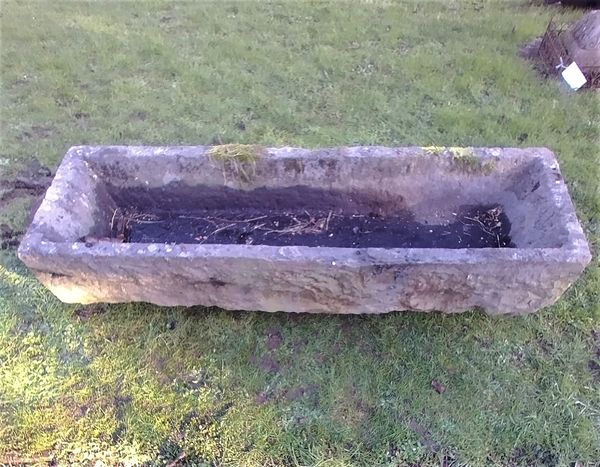 A rectangular carved bluestone trough