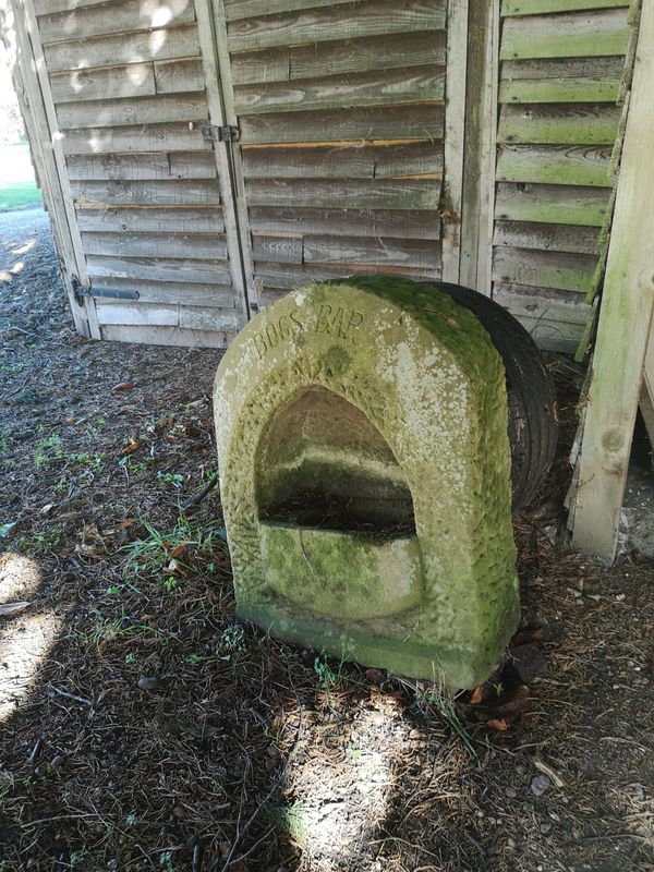 An unusual carved stone dog bowl niche