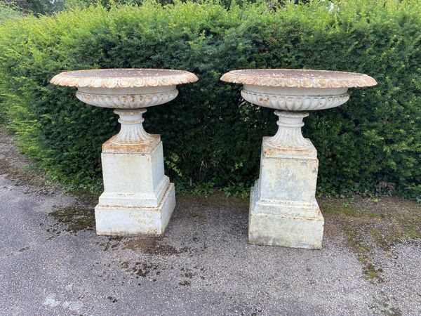 A pair of rare and unusually large Handyside foundry cast iron urns on pedestals