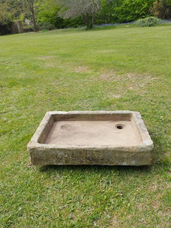 A shallow carved Cotswold stone trough