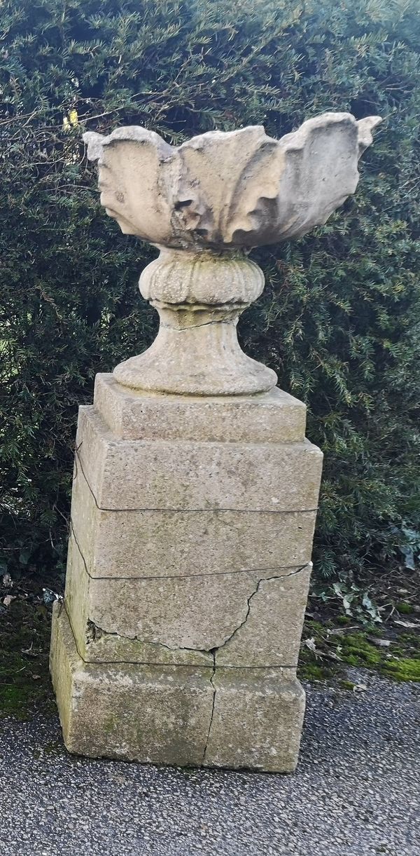 A composition stone urn on pedestal, possibly by Austin & Seeley