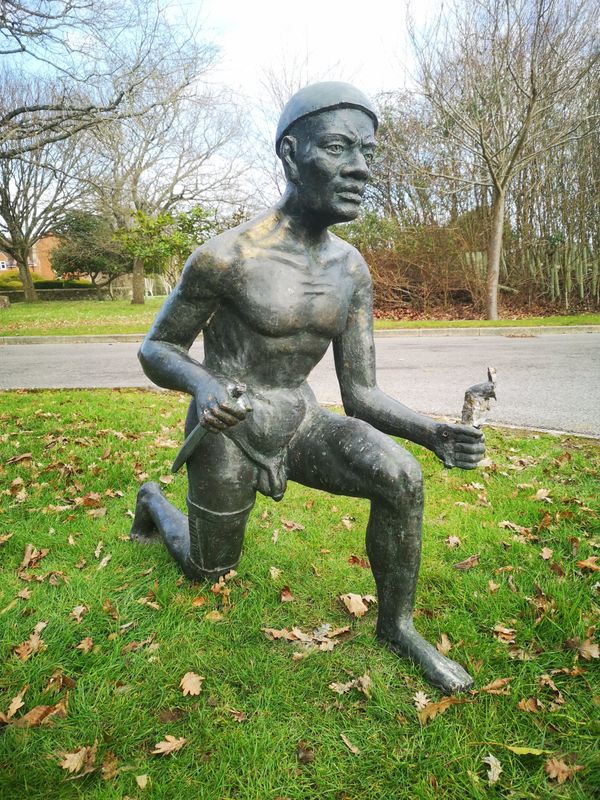 A bronze figure of a kneeling Zulu warrior