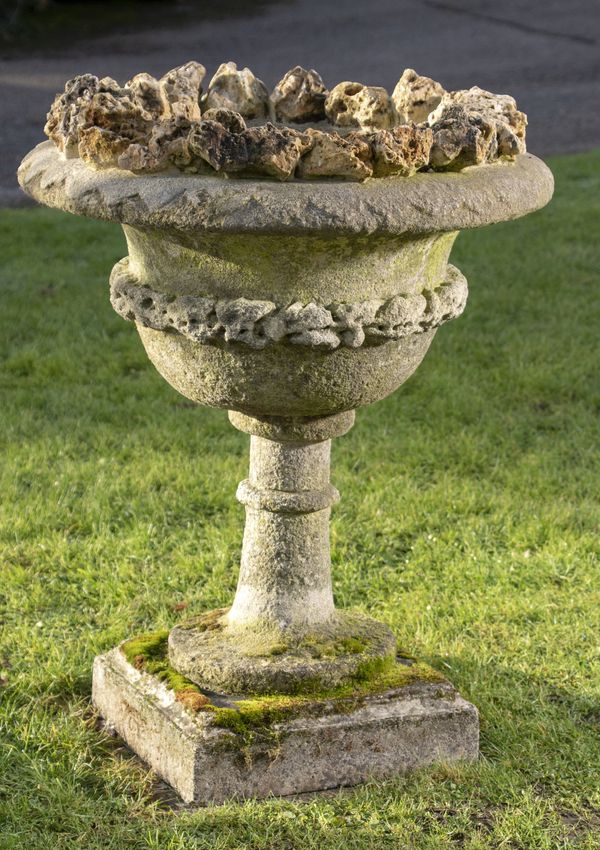 A carved stone urn with later tufastone