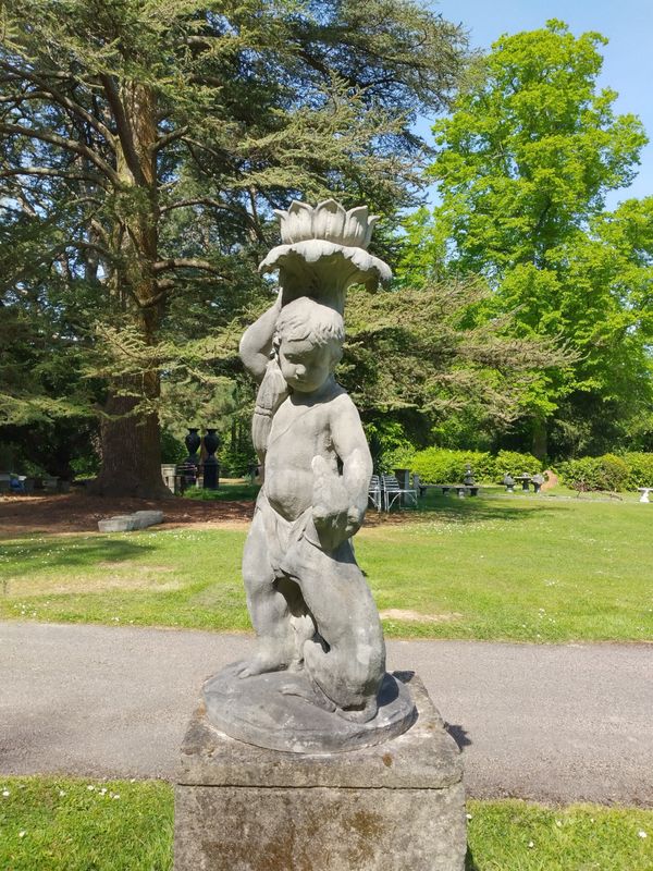 A composition stone fountain of a figure of a boy and dog