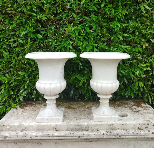 A similar pair of carved white marble urns