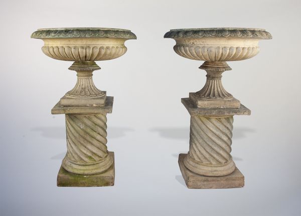 A large pair of fireclay urns on pedestals
