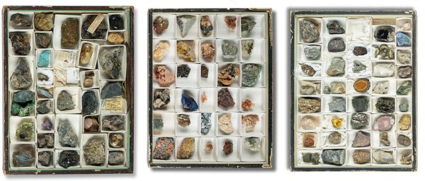 A set of three museum cases housing a collection of minerals