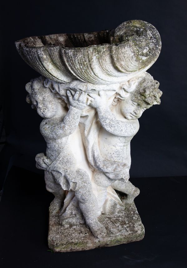 A composition stone figure of two cherubs holding a shell bowl