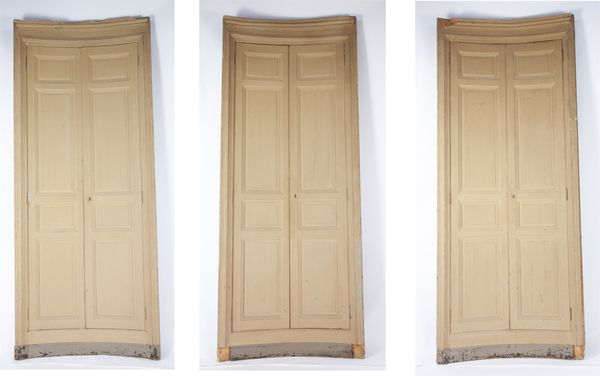 A set of three unusual curved wooden doors and surrounds