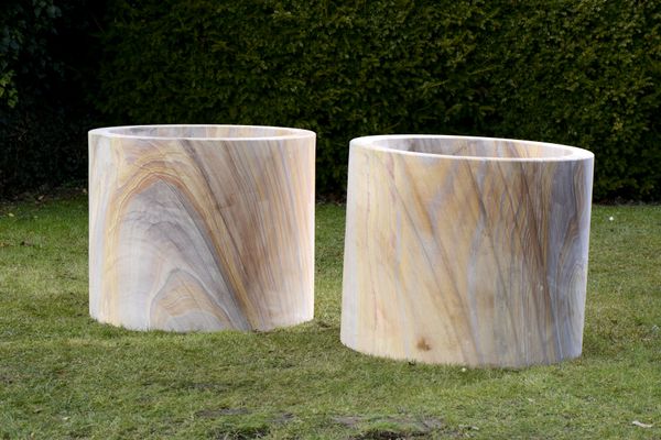 †A pair of substantial sandstone cylindrical wellhead/planters