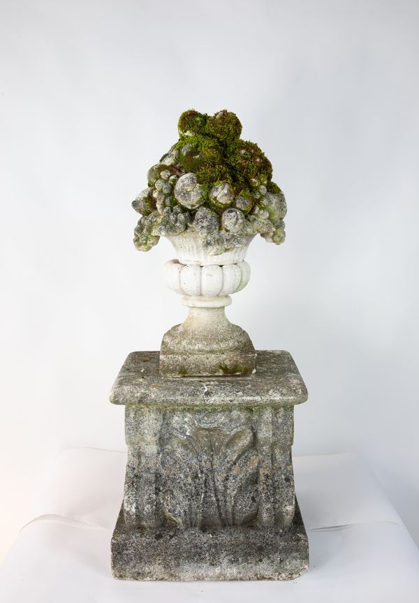 A composition stone basket of fruit on pedestal