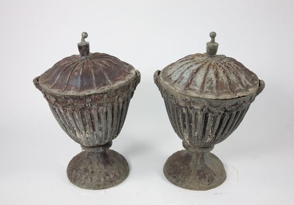 A pair of lead lidded urns